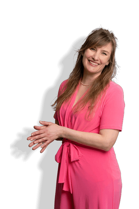 Maartje Booij, eine lächelnde Frau mit langem Haar, trägt ein leuchtend rosa Kleid und posiert mit gefalteten Händen vor einem weißen Hintergrund mit einem dunklen Schatten hinter ihr.